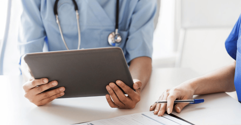 Image shows a doctor using a tablet.